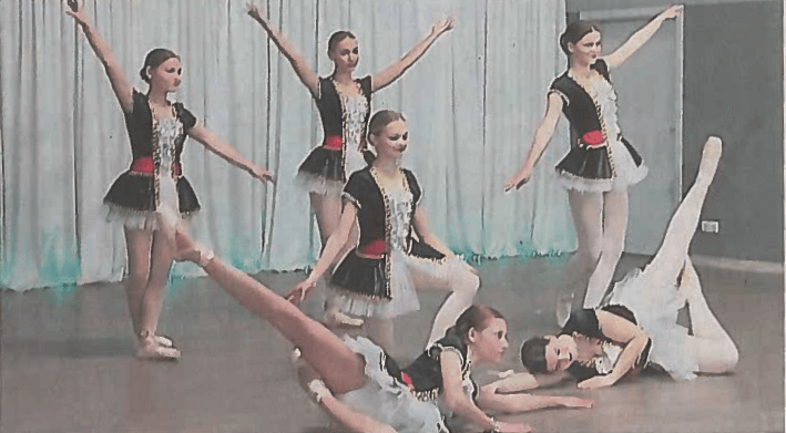 6 Tänzerinnen in einer Gruppenpose auf einer Bühne